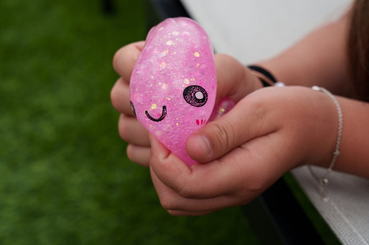 Close-up of hands squeezing a pink glitter squishy dumpling toy